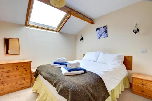 une chambre avec un lit avec des serviettes dessus dans l'établissement Wagtail Cottage, à Tosside