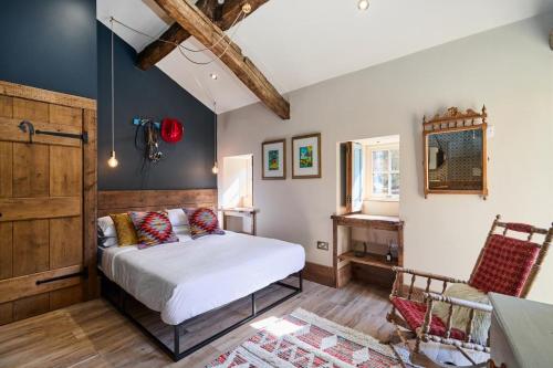 a bedroom with a bed and a table and a window at Hardwick House Barn in Addingham