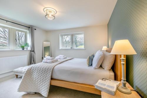 a bedroom with a bed and a lamp and windows at Spring Bank View - Holmfirth in Holmfirth