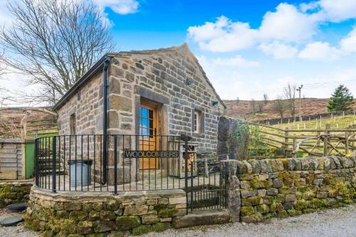 a stone house with a gate and a stone wall at Woolcombers in Addingham