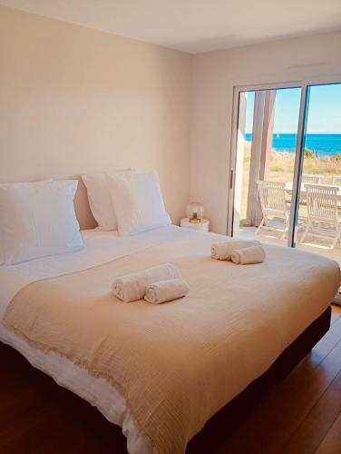 a bedroom with a large bed with two towels on it at Maisons Bodenn - Villa de Pors Riagat Front de Mer in Plobannalec-Lesconil