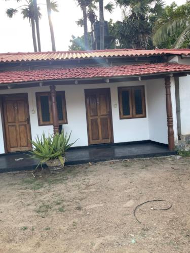 a small white house with a red roof at Anandas Beach Resort in Trincomalee
