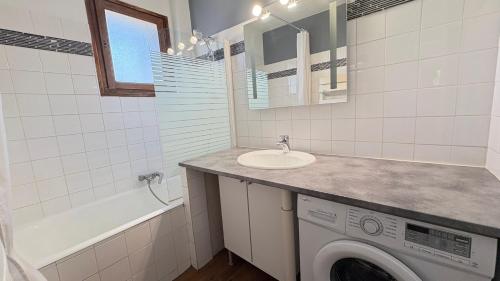 une salle de bain avec une machine à laver et un lavabo dans l'établissement Centre ville avec vue exceptionnelle, à Font-Romeu-Odeillo-Via