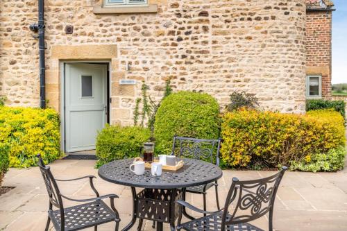 a table and chairs on a patio in front of a building at Obed Husseys in Crakehall
