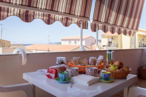 a table with a basket of fruits and vegetables on it at White Beach in Alghero