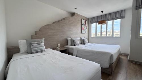 a bedroom with two beds and a staircase at Methavalai Residence Hotel in Bangkok