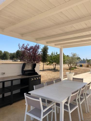 a patio with a table and chairs and a stove at white moon holiday home in Ostuni