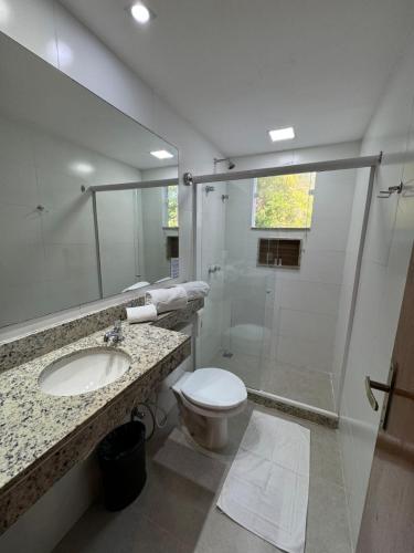 a bathroom with a shower and a toilet and a sink at Pousada Camarote Itaipu in Niterói