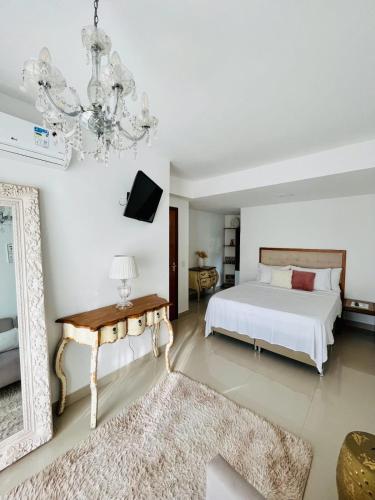 a bedroom with a bed and a mirror and a chandelier at Pousada Camarote Itaipu in Niterói