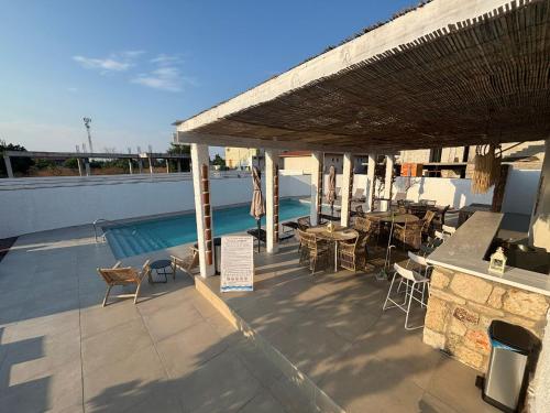 a patio with a table and chairs and a swimming pool at Vila Alaris Vama Veche in Vama Veche
