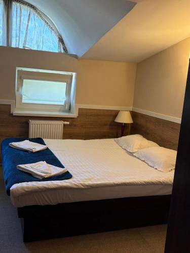 a bedroom with a large bed with a window at Villa Sulejówek in Sulejówek