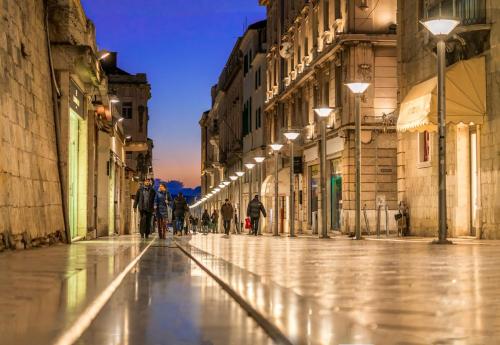 a group of people walking down a street with lights at NEW! Oldie but goldie in Split