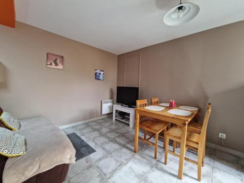 a room with a table and chairs and a television at gites de l'archange in Courtils