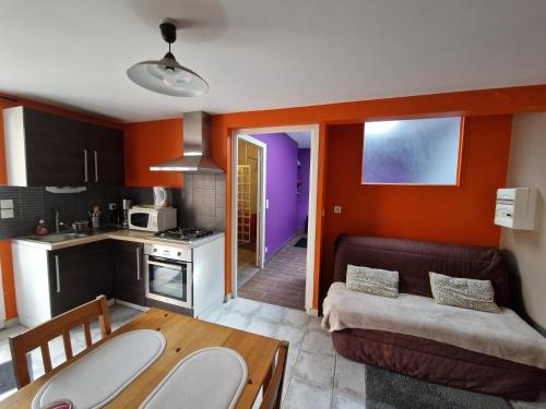 a kitchen with a table and a couch in a room at gites de l'archange in Courtils