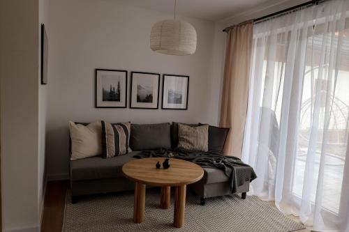 a living room with a couch and a table at Leśne Chatki - Apartamenty Świerk i Sosna in Koniaków