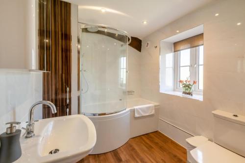 un bagno bianco con lavandino e doccia di Well Cottage - West Burton a West Burton