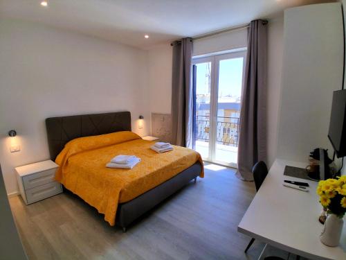 a bedroom with a bed and a window and a desk at Virgy White rooms in Bari