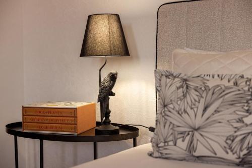 a lamp sitting on a table next to a bed at Porta do Jardim in São Pedro do Sul