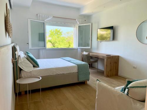 a bedroom with a bed and a desk and a window at Elis rooms & suite in Olbia