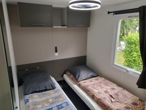two beds in a small room with a window at Domaine De Dugny in Veuzain-sur-Loire