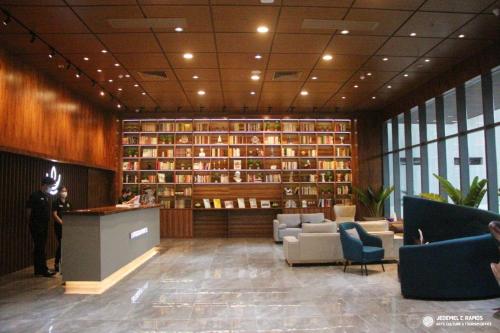 a lobby with a library with couches and books at LOTUS BLU HOTEL Naga 