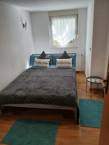 una camera da letto con un letto blu con cuscini e una finestra di Relax - Beautiful 2 rooms a Satteldorf