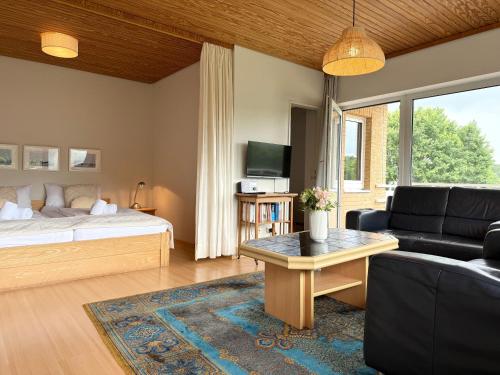 a living room with a bed and a couch at Apartmenthaus Frauenpreiss FeWo 214 in Cuxhaven