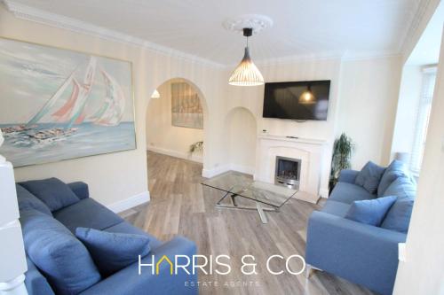 un soggiorno con divani blu e camino di Poolfoot Villas a Thornton