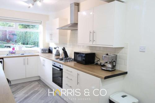 una cucina bianca con mobili bianchi e un lavello di Poolfoot Villas a Thornton