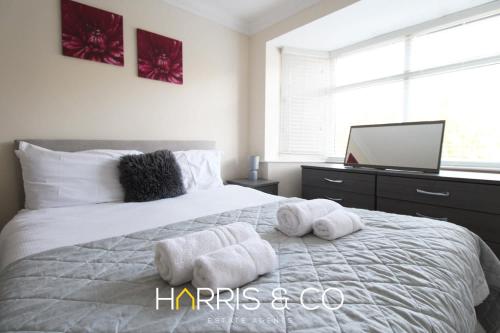 a bedroom with a white bed with towels on it at Poolfoot Villas in Thornton