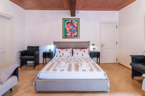 a bedroom with a bed and two chairs in it at Casa Nina Bologna Centro in Bologna