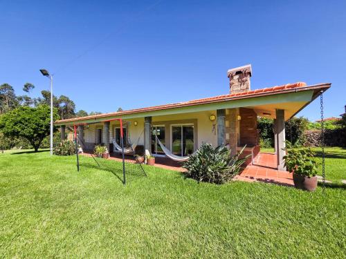 a small house with a porch and a yard at Casa das Quintas - Refúgio Rural com Piscina in Além da Ribeira