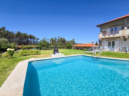 a swimming pool in front of a house at Casa das Quintas - Refúgio Rural com Piscina in Além da Ribeira