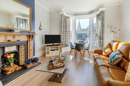 a living room with a couch and a fireplace at The Blue Door Apartment in Bridlington