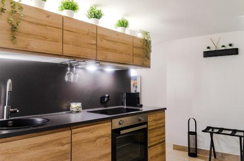 a kitchen with a black counter top and wooden cabinets at Maison de l'aiR - apt with Jacuzzi in Giovinazzo
