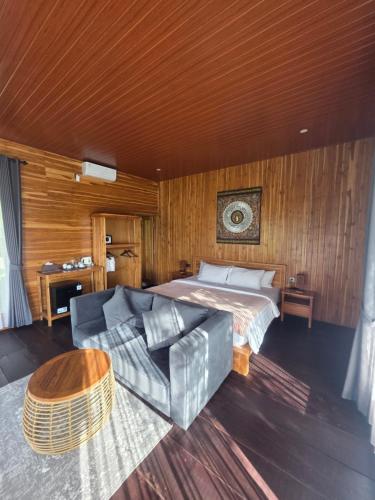 a bedroom with a bed and a couch and a table at MAYURA BALI VILLA in Munduk