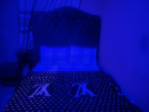 a blue room with a bed with two x signs on it at The Guest House in Ilado