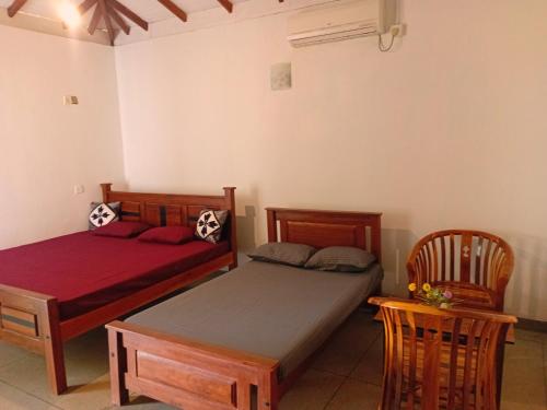 une chambre avec deux lits et une table et des chaises dans l'établissement heritage Kalawewa holiday resort, à Balaluwewa