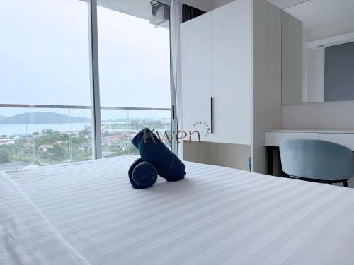 a bedroom with a bed with a blue bag on it at KWEN Suites-Tanjung Aru InfinityPool Seaview/Airport View in Kota Kinabalu