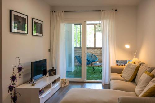 een woonkamer met een bank en een televisie bij Estancia Mar y Montaña in Jávea