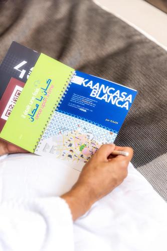 a person is reading a book on a bed at Kaan Casablanca in Casablanca