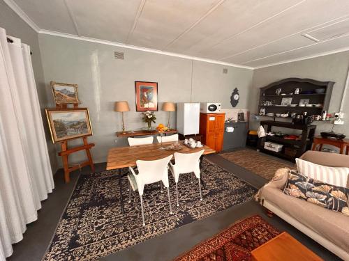 Una sala de estar con una mesa y sillas y un sofá. en Pied Cow Cottage, en Hilton