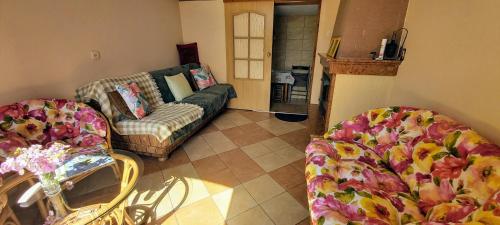 a living room with two chairs and a couch at Dom Pod Gruszą in Chmielno