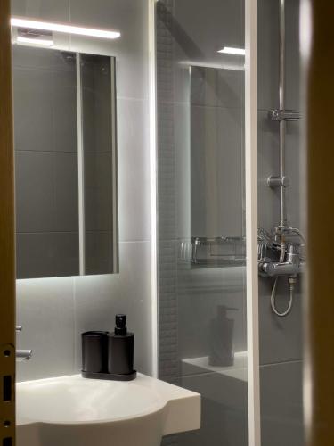 a white bathroom with a sink and a mirror at Casa Maria-Anneta in Kalyves Poligirou