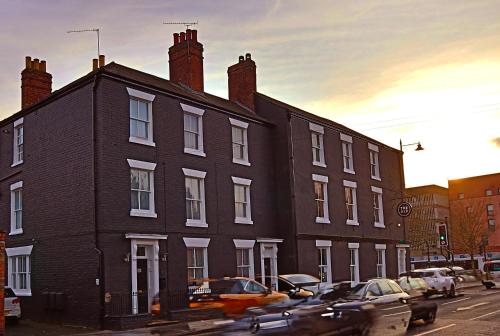 a black building with cars parked in front of it at The Alb in Shrewsbury