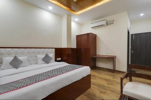 a bedroom with a large bed and a chair at RROOMS Trijal Hotel Banquet in Lucknow
