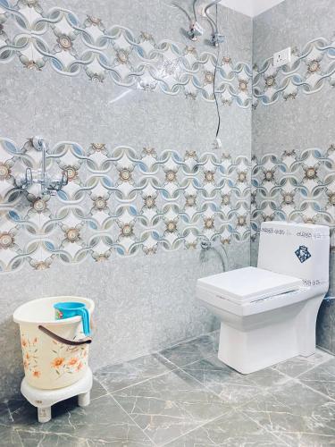 La salle de bains est pourvue de toilettes et d'un mur. dans l'établissement Hotel Tara Palace By MIDTOWN, à Katra