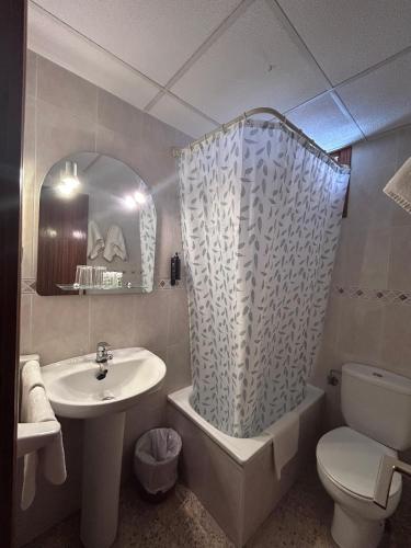 a bathroom with a sink and a toilet and a shower at Hostal Susi in Peniscola