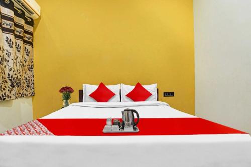 a bedroom with a large bed with red pillows at Hotel O Mauris Inn & Restaurant in Mānglia