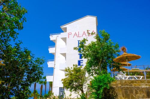 a white building with a sign on it at Hotel Palasa in Palasë
